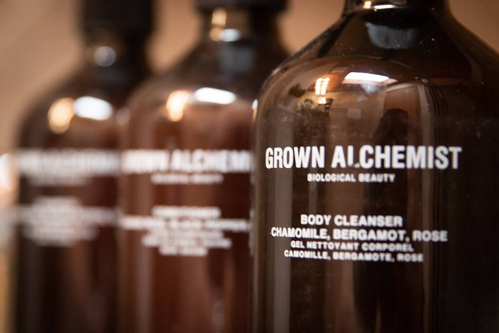 Three brown bottles with grown alchemist written in white on them