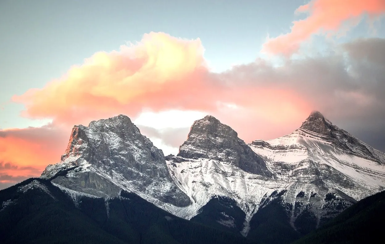 Perched gracefully in the Canadian Rockies, near the charming town of Canmore, Alberta, the Three Sisters Mountains stand as a breathtaking and iconic landmark.